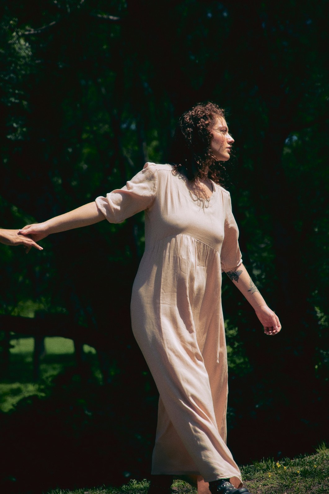 A woman in a cream costume walking through a forest