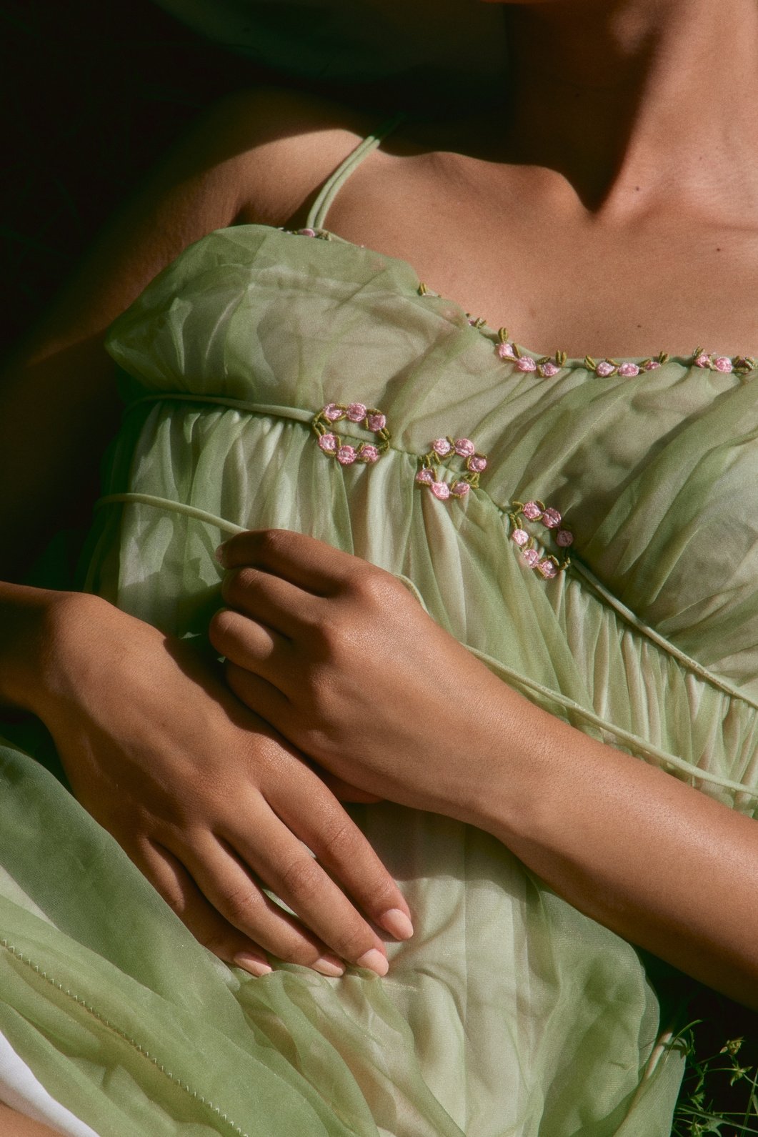 Close-up of a green costume with embroidered floral details