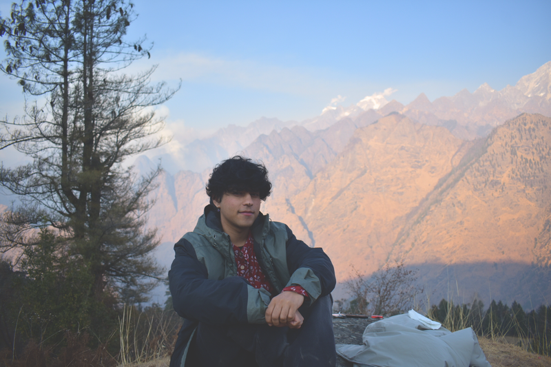Aditya seated before the Himalayan mountains
